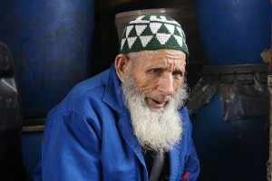 Un vieux papa Marocain assis devant son épicerie